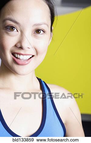 Stock Photo - Filipino woman smiling in gym. Fotosearch