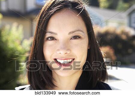 Stock Photo - Filipino woman smiling outdoors. Fotosearch