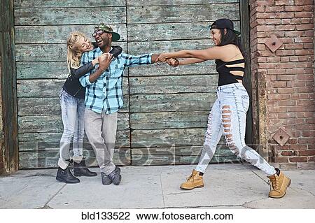 Stock Image - Friends posing on city street. Fotosearch