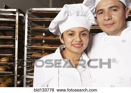Stock Photo - Hispanic bakers smiling in bakery. Fotosearch