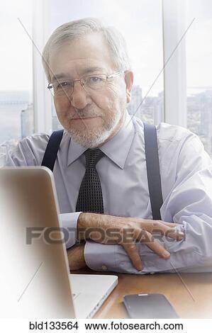 Picture - Hispanic businessman working at desk. Fotosearch