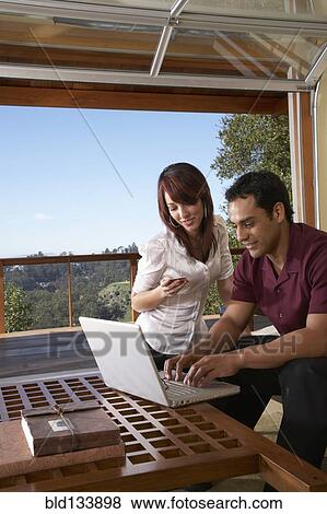 Stock Photo - Hispanic couple using laptop together. Fotosearch