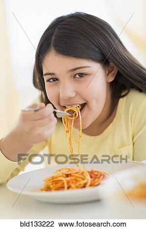 Hispanic girl eating plate of pasta View Large Photo Image Stock Image - Hispanic girl eating plate of pasta. Fotosearch
