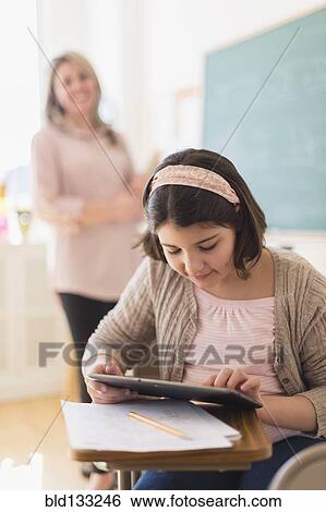 Hispanic girl using digital tablet in classroom View Large Photo Image Stock Photograph - Hispanic girl using digital tablet in classroom. Fotosearch