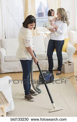 Hispanic girl vacuuming living room View Large Photo Image Stock Image - Hispanic girl vacuuming living room. Fotosearch