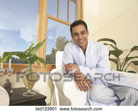 Stock Image - Hispanic man sitting in armchair. Fotosearch