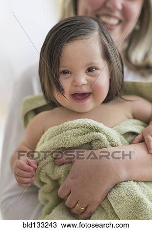 Stock Image - Hispanic mother drying toddler daughter after bath. Fotosearch