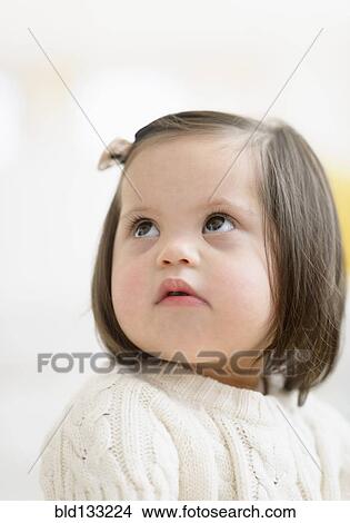 Picture - Hispanic toddler with Down syndrome looking up. Fotosearch
