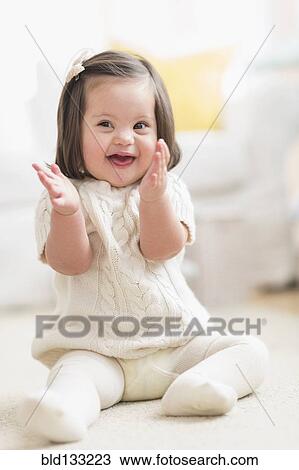 Stock Image - Hispanic toddler with Down syndrome playing. Fotosearch