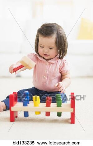 Stock Photography - Hispanic toddler with Down syndrome playing. Fotosearch