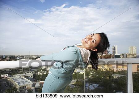 Hispanic woman on balcony overlooking urban cityscape View Large Photo Image Stock Photo - Hispanic woman on balcony overlooking urban cityscape. Fotosearch
