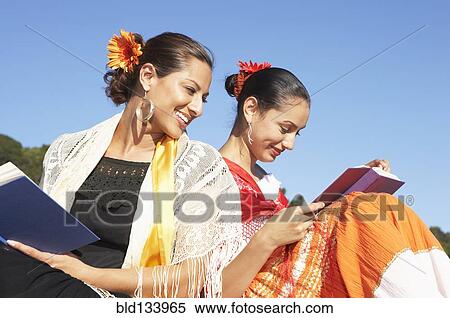 Stock Photography - Hispanic women reading in traditional clothing. Fotosearch