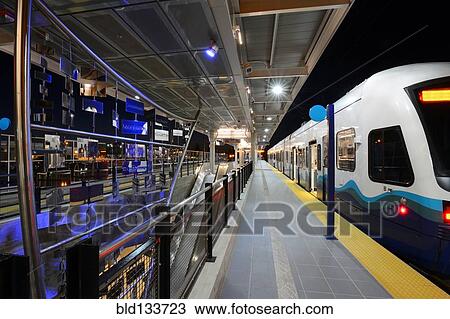 Stock Image - Light rail pulling into station. Fotosearch