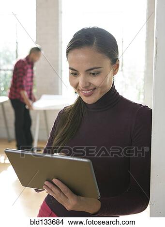 Picture - Mixed race architect using digital tablet in office. Fotosearch