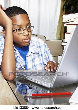 Mixed race boy using laptop View Large Photo Image Picture - Mixed race boy using laptop. Fotosearch