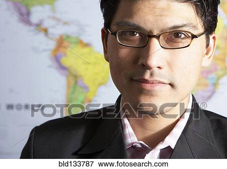 Stock Photo - Mixed race businessman standing by world map. Fotosearch