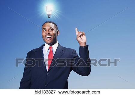 Mixed race businessman with light bulb over his head View Large Photo Image Stock Photo - Mixed race businessman with light bulb over his head. Fotosearch