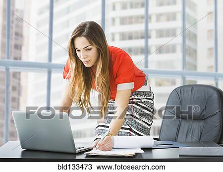 Mixed race businesswoman working at desk View Large Photo Image Stock Image - Mixed race businesswoman working at desk. Fotosearch