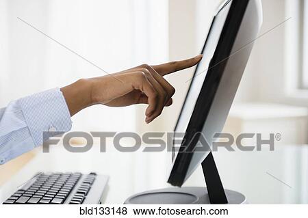 Stock Photo - Mixed race businesswoman working on touch screen computer. Fotosearch