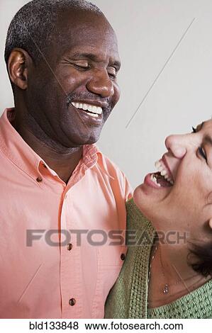 Stock Photo - Mixed race couple laughing together. Fotosearch