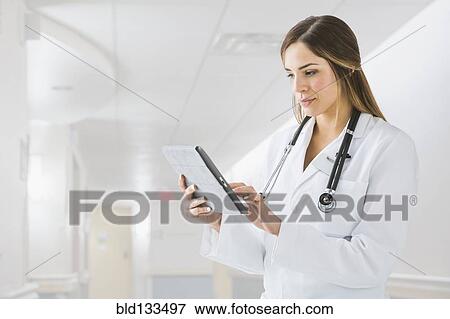 Mixed race doctor using digital tablet in hospital View Large Photo Image Stock Photo - Mixed race doctor using digital tablet in hospital. Fotosearch