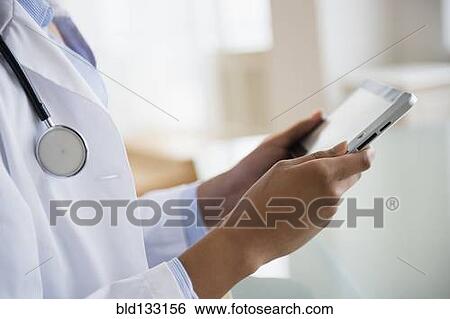 Mixed race doctor using digital tablet View Large Photo Image Stock Photograph - Mixed race doctor using digital tablet. Fotosearch