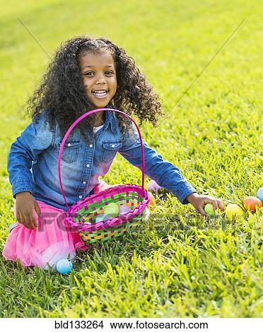Mixed race girl hunting for Easter eggs View Large Photo Image Picture - Mixed race girl hunting for Easter eggs. Fotosearch