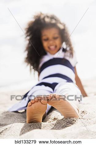 Mixed race girl playing in sand on beach View Large Photo Image Stock Photo - Mixed race girl playing in sand on beach. Fotosearch
