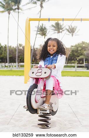 Stock Photo - Mixed race girl playing on playground. Fotosearch