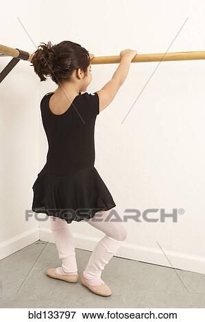 Stock Photo - Mixed race girl practicing ballet in studio. Fotosearch