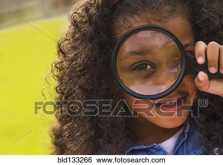 Stock Photograph - Mixed race girl using magnifying glass. Fotosearch