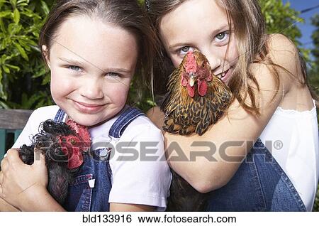 Mixed race girls holding chickens on farm View Large Photo Image Stock Photograph - Mixed race girls holding chickens on farm. Fotosearch