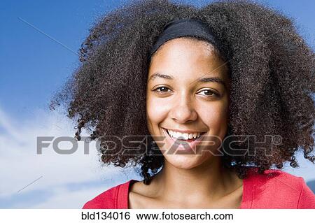 Stock Photograph - Mixed race teenage girl smiling outdoors. Fotosearch