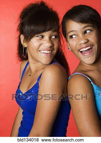 Mixed race teenage twin girls smiling View Large Photo Image Stock Photo - Mixed race teenage twin girls smiling. Fotosearch