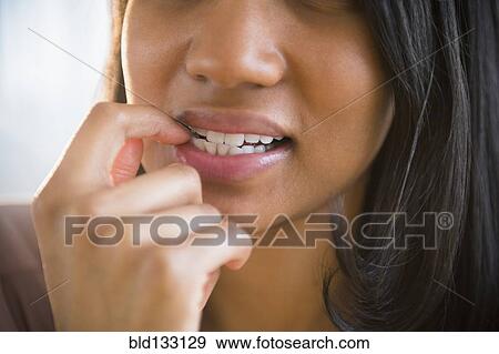 Mixed race woman biting her nail View Large Photo Image Stock Photo - Mixed race woman biting her nail. Fotosearch