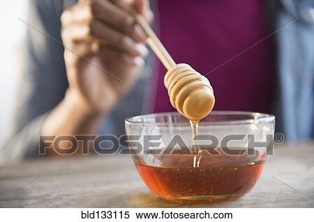 Mixed race woman holding honey dipper View Large Photo Image Stock Photography - Mixed race woman holding honey dipper. Fotosearch