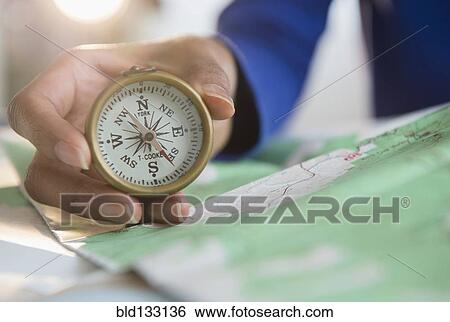Mixed race woman holding map and compass View Large Photo Image Stock Photograph - Mixed race woman holding map and compass. Fotosearch