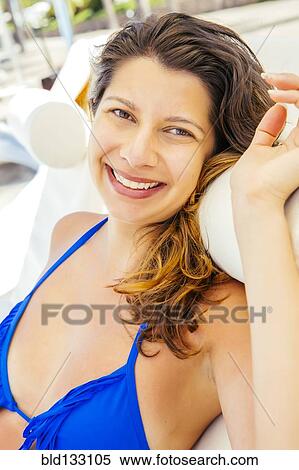 Stock Photography - Mixed race woman relaxing on beach. Fotosearch