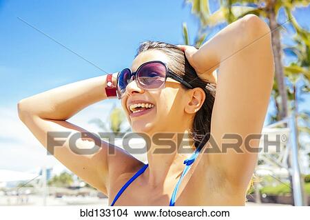 Picture - Mixed race woman smiling on beach. Fotosearch