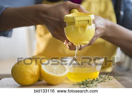 Mixed race woman squeezing lemons View Large Photo Image Stock Photograph - Mixed race woman squeezing lemons. Fotosearch