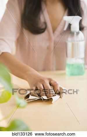 Stock Photograph - Mixed race woman wiping countertop. Fotosearch