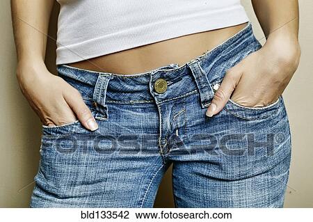 Stock Image - Mixed race woman with hands in pockets. Fotosearch