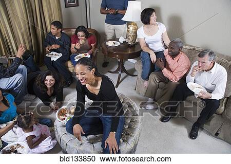 Stock Image - Multi-generation family relaxing together in living room. Fotosearch