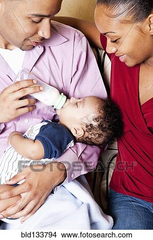 Parents bottle feeding baby View Large Photo Image Picture - Parents bottle feeding baby. Fotosearch