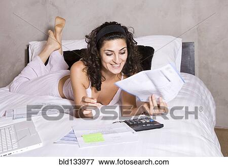 Persian woman paying bills on bed View Large Photo Image Stock Photo - Persian woman paying bills on bed. Fotosearch