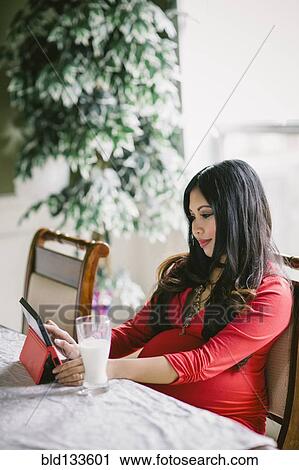 Pregnant Asian woman using digital tablet View Large Photo Image Stock Image - Pregnant Asian woman using digital tablet. Fotosearch
