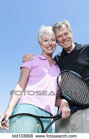 Senior Caucasian couple holding tennis rackets View Large Photo Image Stock Photo - Senior Caucasian couple holding tennis rackets. Fotosearch