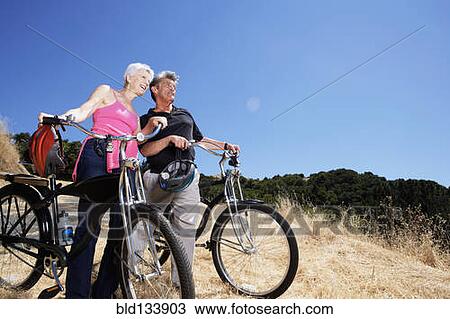 Senior Caucasian couple wheeling dirt bikes on hilltop View Large Photo Image Stock Image - Senior Caucasian couple wheeling dirt bikes on hilltop. Fotosearch