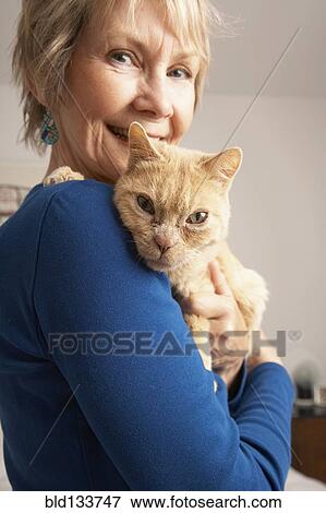 Stock Photo - Senior Caucasian woman holding cat. Fotosearch