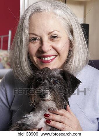 Stock Photograph - Senior Caucasian woman petting dog. Fotosearch